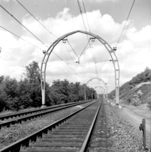 HUA-167164-Gezicht op de spoorlijn tussen Hilversum en Hollandsche Rading, met de halfronde betonnen bovenleidingsportalen ("driescharnierenboog-constructie")