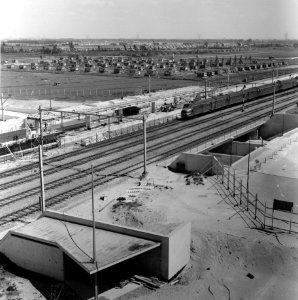 HUA-166776-Gezicht op het in aanbouw zijnde N.S.-station Rotterdam Lombardijen te Rotterdam, met een passerend electrisch treinstel mat. 1954 (plan P) van de N.S