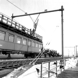 HUA-166482-Afbeelding van het aanbrengen van de bovenleiding boven een spoorlijn, met behulp van een tot montagewagen omgebouwd rijtuig mat. 1924 ("Blokkendozen") van de N.S photo