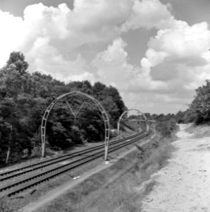 HUA-167165-Gezicht op de spoorlijn tussen Hilversum en Hollandsche Rading, met de halfronde betonnen bovenleidingsportalen ("driescharnierenboog-constructie")