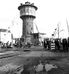 HUA-166549-Gezicht op de spoorwegovergang in de Schrans te Leeuwarden, met op de achtergrond het seinhuis Post D en de in 1972 afgebroken watertoren