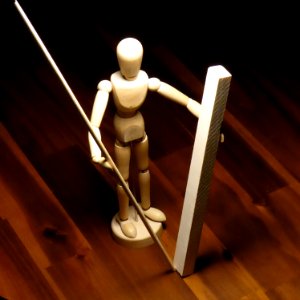 Holzfigur mit Stäben