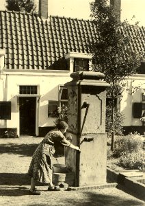 Hofje van Loo of Gasthuishofje, noordzijde der binnenplaats met pomp. Aangekocht in 1976 van fotograaf C. de Boer. Identificatienummer 54-011248, NL-HlmNHA 54011248
