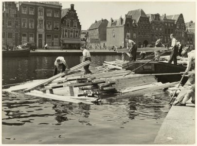 Hout lossen op het Spaarne bij de Helmbrekersteeg ziende naar het westen. NL-HlmNHA 54010636