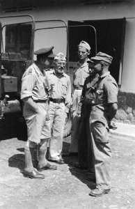 Hoofdaalmoezier Van Stralen praat met KNIL militairen in gezelschap van aalmoeze, Bestanddeelnr 184-2-3