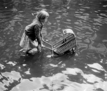 Hoogwater te Amsterdam. Ondergelopen straten. Meisje met rotan kinderwagen, Bestanddeelnr 904-7206