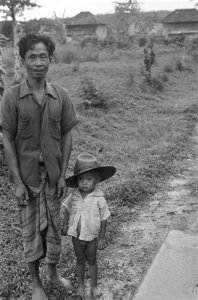 Indonesische man (landarbeider of boer) met een kleine peuter, die een grote hoe, Bestanddeelnr 124-2-1