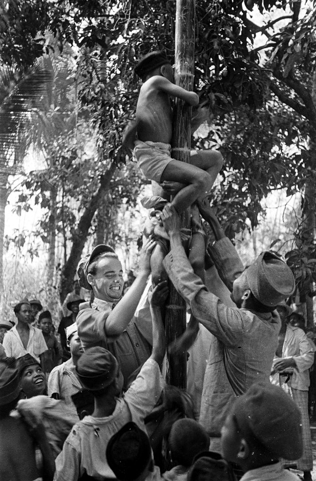 Indonesische jongens klimmen in een paal aangemoedigd door militairen, Bestanddeelnr 7112