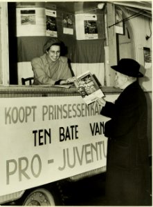 In een stand op de grote markt verkoopt mevrouw Cremers-de Bruijn Prinsessenkalenders ten bate van Pro Juventute, NL-HlmNHA 5400464771