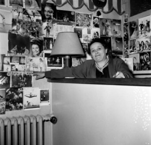 In de bar van de school wijst mevrouw Carletti naar een foto van de Frilli-groep, Bestanddeelnr 254-0134