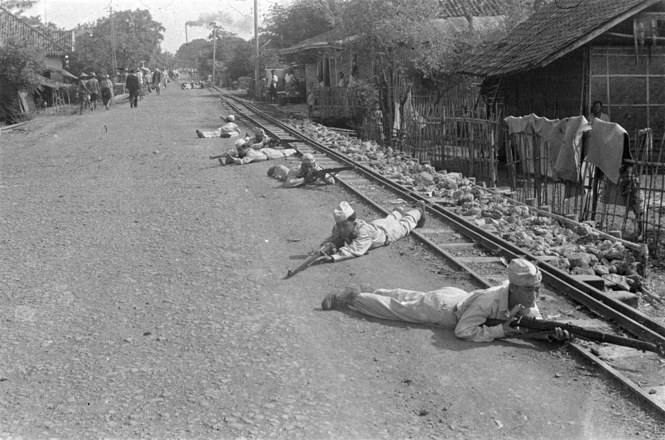 Indonesische recruten liggen in positie langs een tramspoor in een buitenwijk , Bestanddeelnr 456-1-4