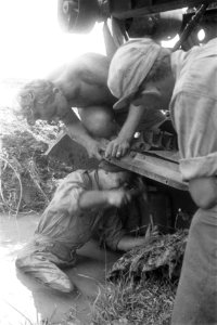 In de modder probeert een militair met hamer en beitel iets los te bikken van e, Bestanddeelnr 255