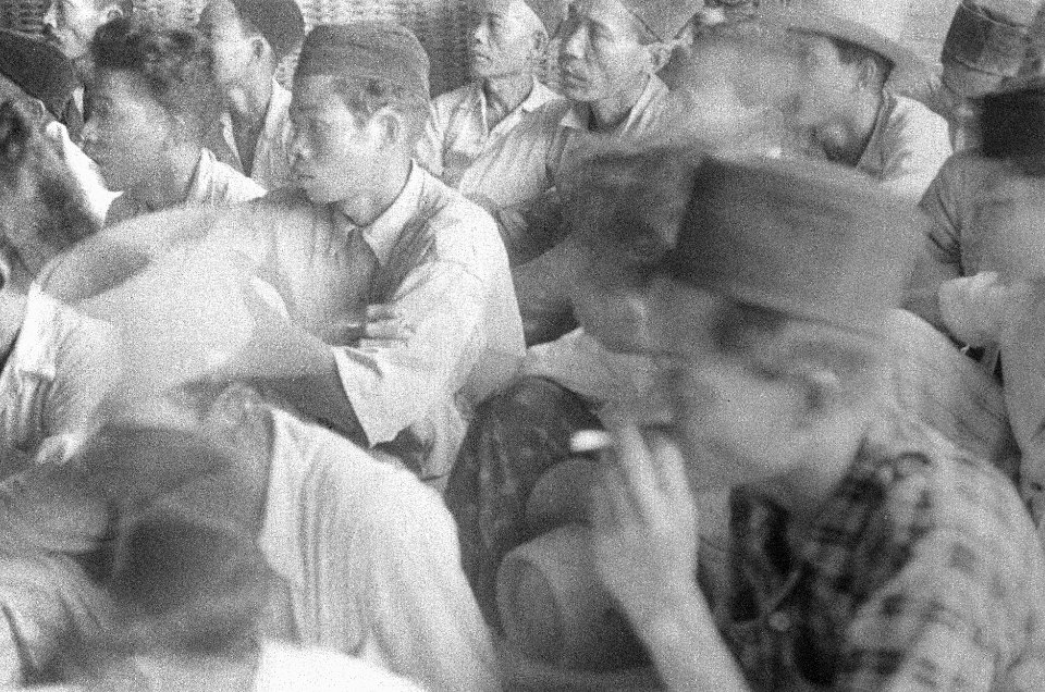 Indonesische jonge mannen met pecis luisteren naar een toespraak, Bestanddeelnr 50-5-2