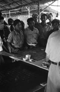 Indonesische burgers en militairen spelen een bordspel en zetten geld in, Bestanddeelnr 2287