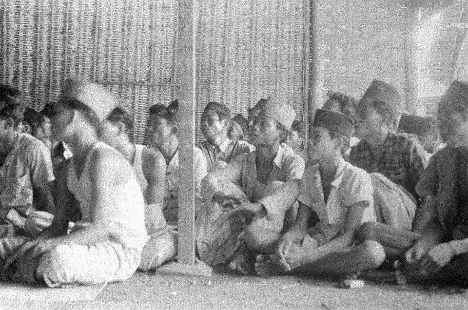 Indonesische jonge mannen met pecis luisteren naar een toespraak, Bestanddeelnr 50-4-1