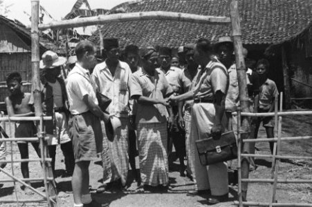 Indonesisch man in uniform schudt handen met. Links de Europese man, Bestanddeelnr 50-5-4