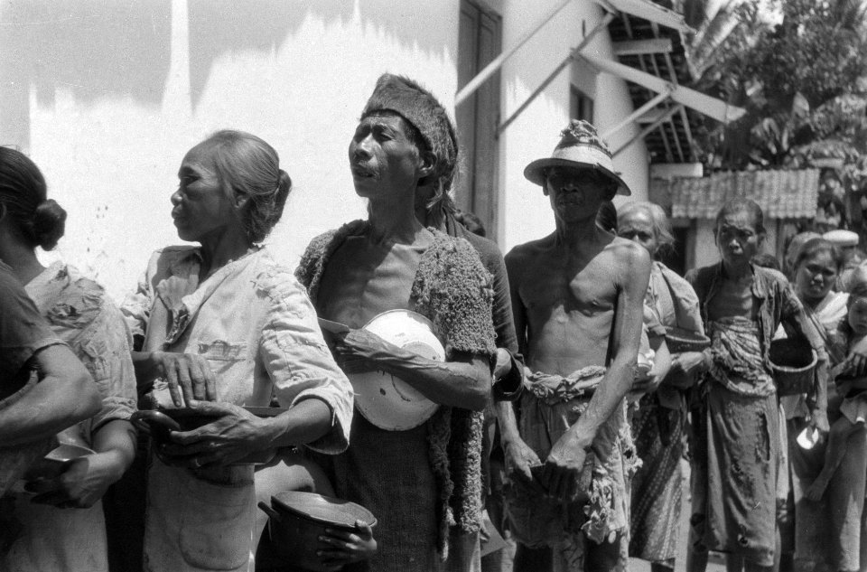 Indonesische mannen en vrouwen met borden in hun handen staan in een rij voor ee, Bestanddeelnr 5454