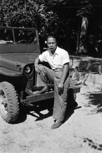 Indonesische (Balinese) man poseert voor een jeep Hij draagt een bloem in zijn, Bestanddeelnr 513-6-7