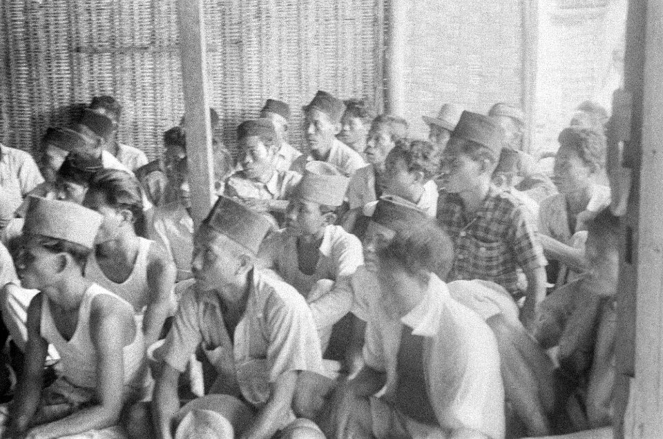 Indonesische jonge mannen met pecis luisteren naar een toespraak, Bestanddeelnr 50-4-5