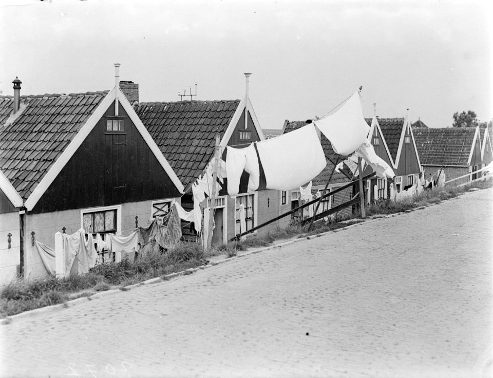 In Volendam hangt het wasgoed vanaf de dijk tot aan de lager gelegen huisjes, Bestanddeelnr 252-0679