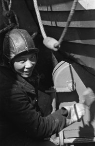 Indonesische zeeman schildert een reddingsboot, Bestanddeelnr 935-2895