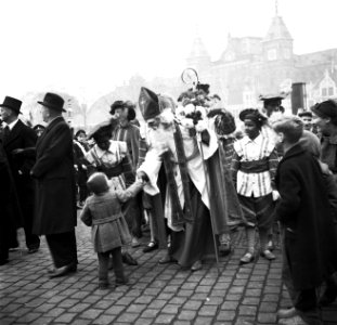 Intocht van Sint-Nicolaas kind geeft Sinterklaas een hand, Bestanddeelnr 254-3537