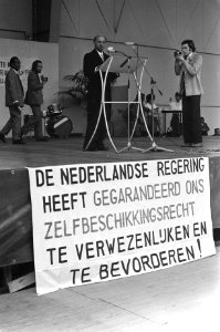 Ir. Manusama spreekt de bijeenkomst toe, op voorgrond een spandoek met opschrif, Bestanddeelnr 925-5558