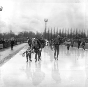 Huldiging schaatsploeg op Jaap Edenbaan te Amsterdam, de rijders met kransen omh, Bestanddeelnr 918-9096
