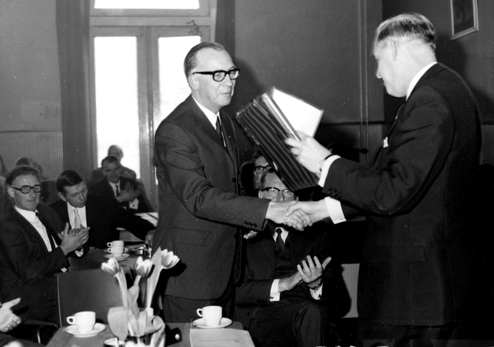 HUA-171913-Afbeelding van de opening van de vernieuwde hal van het N.S.-station Leeuwarden te Leeuwarden, met rechts burgemeester J.S. Brandsma van Leeuwarden die rayonchef C. van Popering een ingelijste reprodu