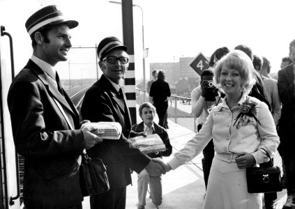 HUA-171920-Afbeelding van plaatsvervangend N.S.-ambassadrice Carla Stenvert die het personeel van de eerste trein op het nieuwe N.S.-station Nieuwerkerk aan de IJssel een presentje overhandigt