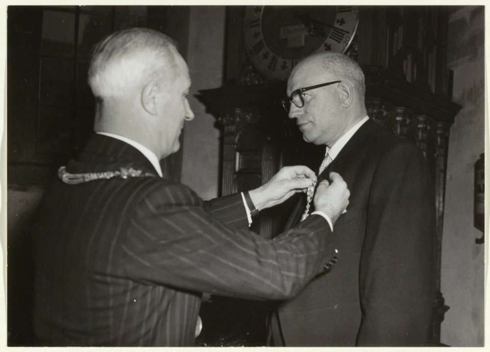Huldiging van de heer B.J. Thijssen (gem. ontvanger) op het stadhuis n.a.v. zijn 40-jarig jubileum. Burgemeester Cremers speldde hem een koninlkijke onderscheiding op. NL-HlmNHA 54002659