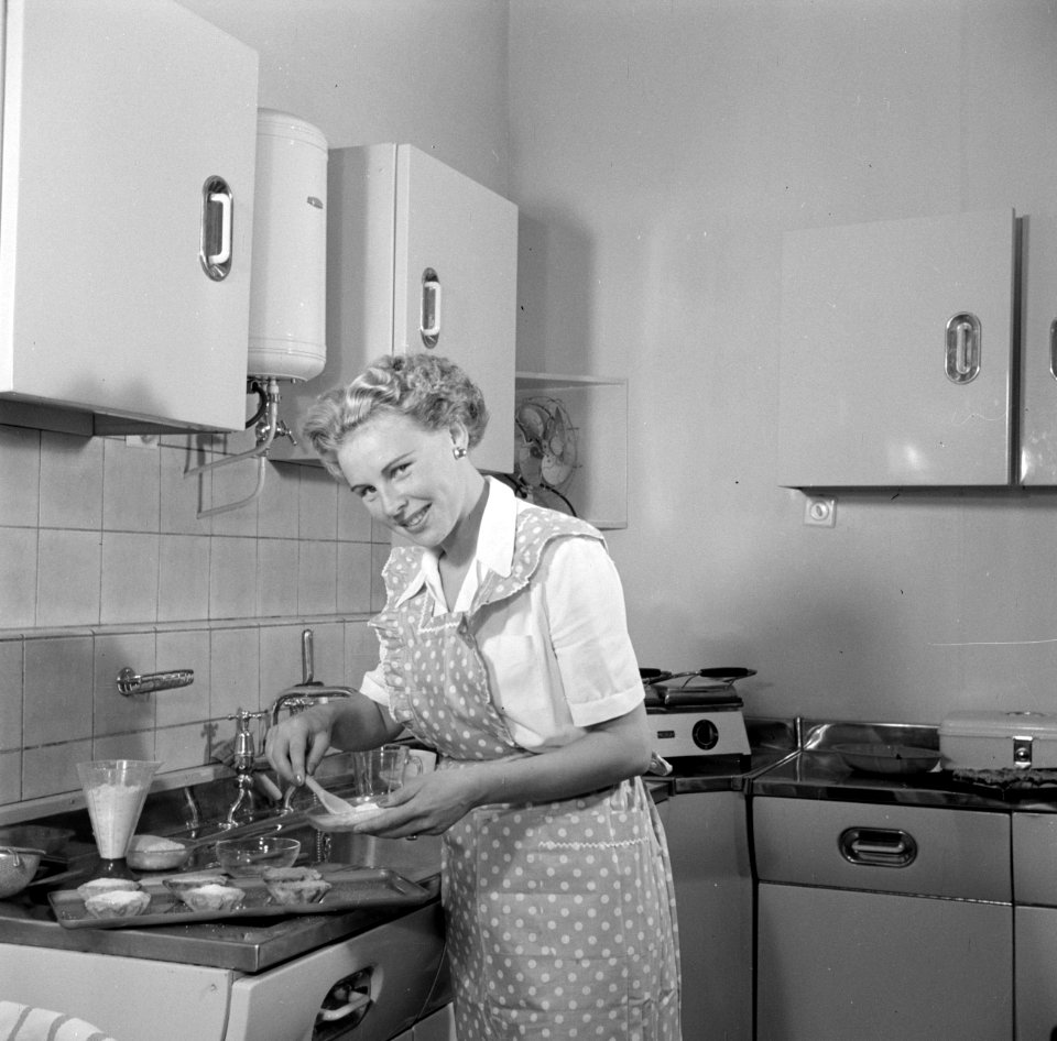 Huisvrouw in modelkeuken bezig met het maken van een taart., Bestanddeelnr 252-1642