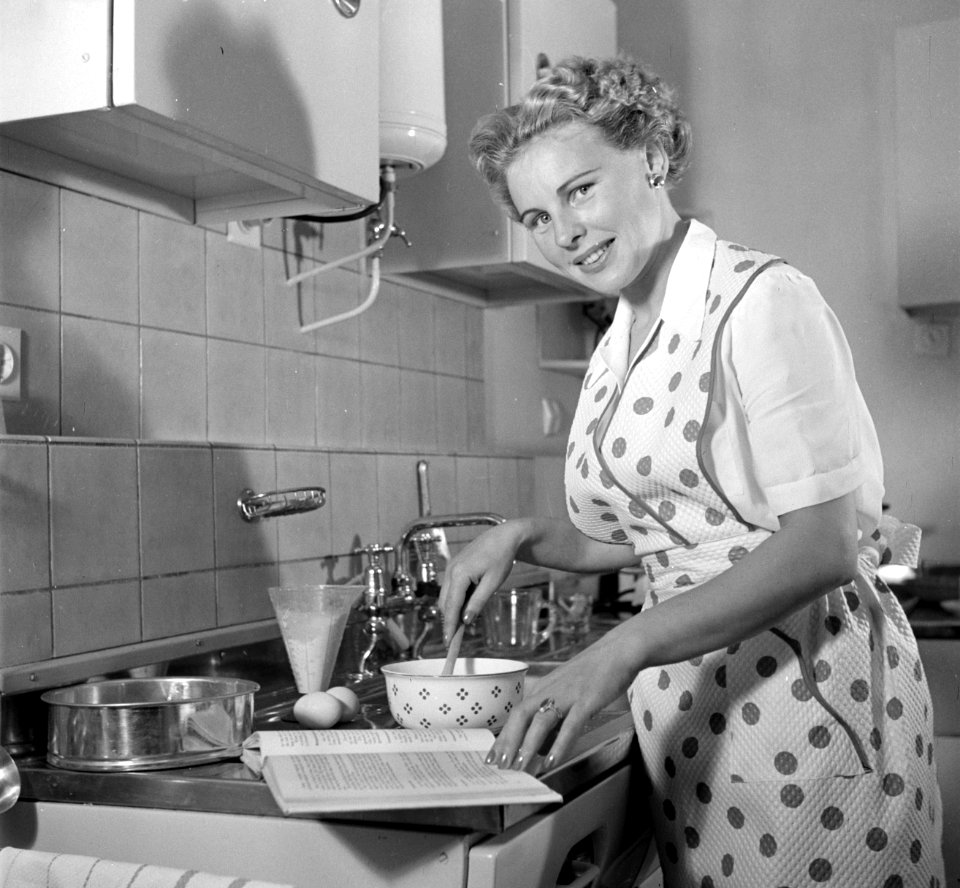 Huisvrouw in modelkeuken bezig met het maken van een taart., Bestanddeelnr 252-1645