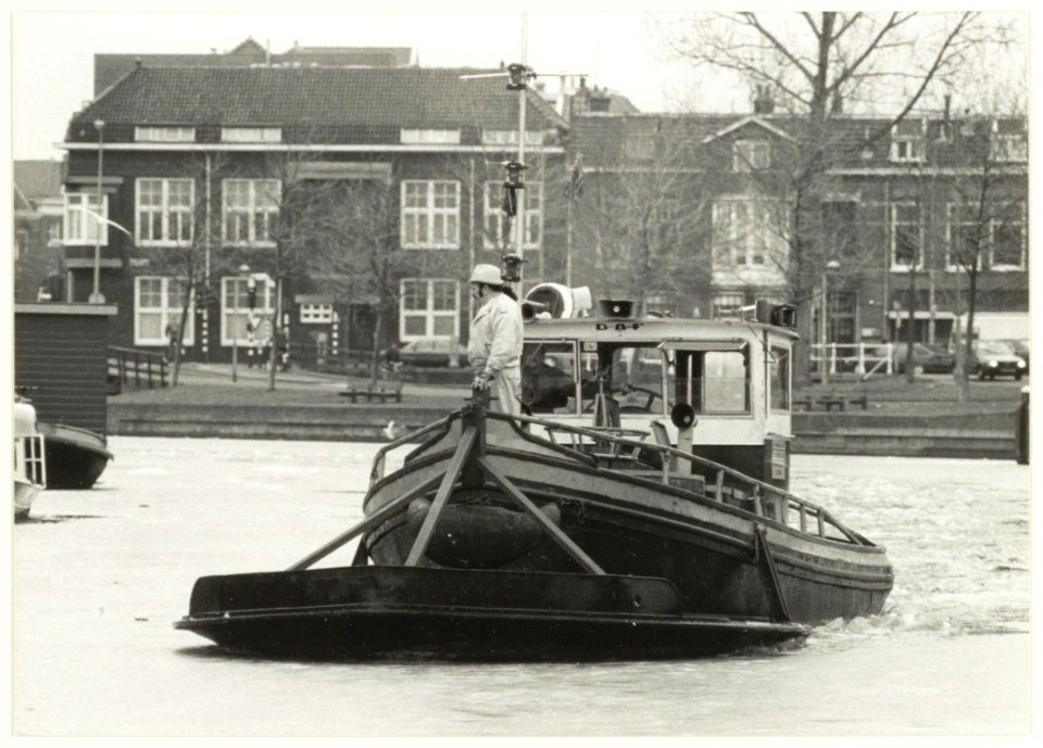 IJsbreker van de fa. Treffers aan het werk op het Spaarne nabij de Langebrug. NL-HlmNHA 54031806