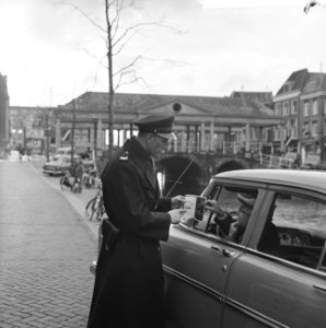In Leiden parkeerschijf ingevoerd Een agent verklaart aan een automobilist het , Bestanddeelnr 915-7776