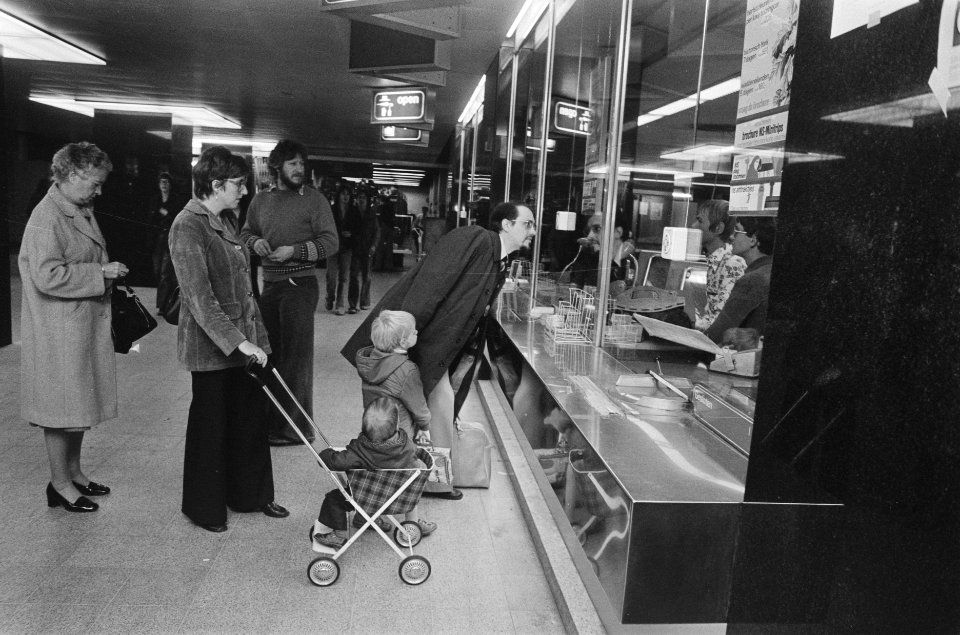 Jong echtpaar met twee kleine kinderen voor loket op Centraal Station, Bestanddeelnr 928-8198