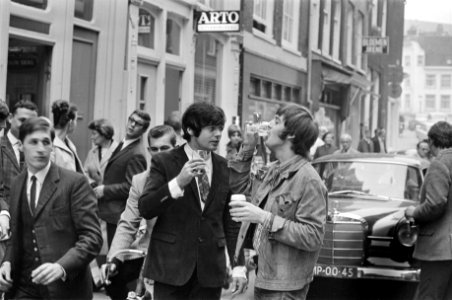 Johnny Lion (midden) en Spencer Davis drinken een glas bier op straat, Bestanddeelnr 919-6296