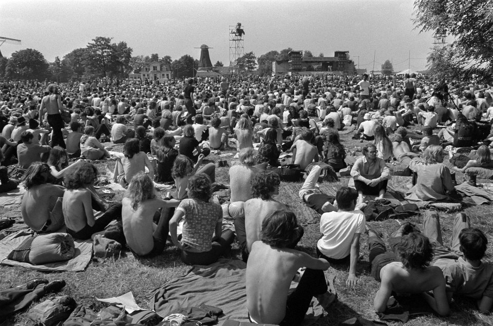 Jeugdige festivalbezoekers in Kralingse Bos zit op het gras voor het podium, Bestanddeelnr 923-6263