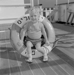 Jongetje met een reddingsboei met Hebreeuws schrift aan boord van een schip, Bestanddeelnr 255-4961