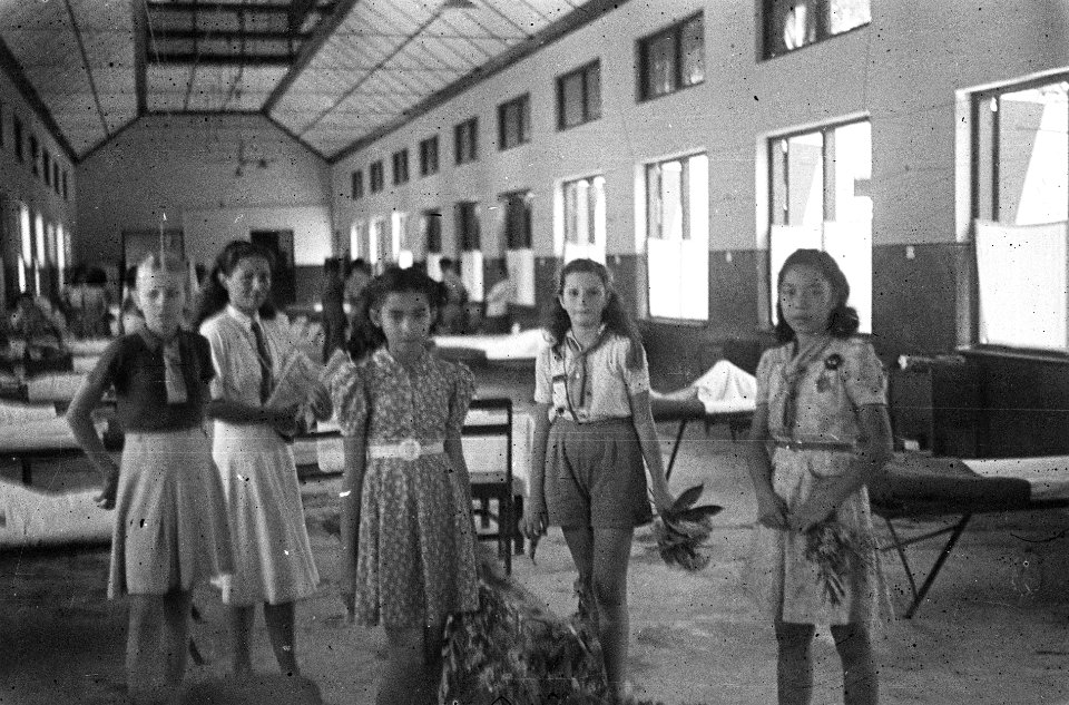 Jonge meisjes, sommigen in scoutingpadvinder uniform, in een ziekenzaal, Bestanddeelnr 5837