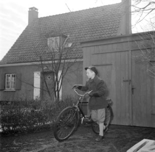 Jongen met fiets op een tuinpad bij een schuur en fietsenrekken, Bestanddeelnr 252-8735 photo