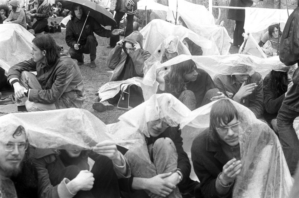 Jongeren zoeken beschutting onder plastic tegen de regen, Bestanddeelnr 925-5653
