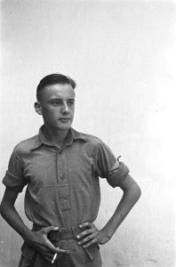 Jonge man in polo-shirt met opgerolde mouwen en armband In zijn rechterhand ee, Bestanddeelnr 521-5-5