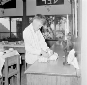 Jongen vouwt servetten ter voorbereiding van de viering van Seideravond (sederma, Bestanddeelnr 255-2836
