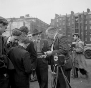 Jongens betalen een straatfotograaf voor hun foto, kort daarvoor genomen met de , Bestanddeelnr 191-0977