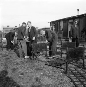 Jongens bezig met het in elkaar zetten van ledikanten, Bestanddeelnr 900-9833