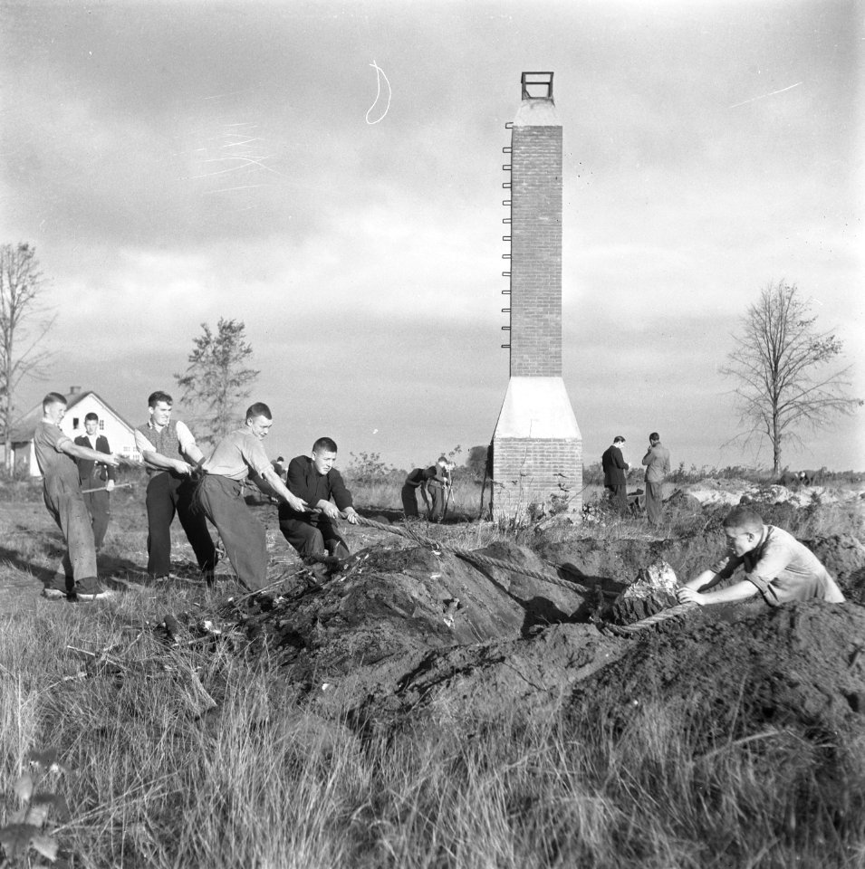 Jongens bezig met rooien van boomstronken Op de achtergrond een schoorsteen, Bestanddeelnr 900-9421