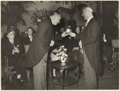 Johan Enschedé aanbieding van de gouden medaille van de stad, aan de heer B.F. Enschedé door burgemeester Cremers wegens het 250-jarig bestaan van de Firma