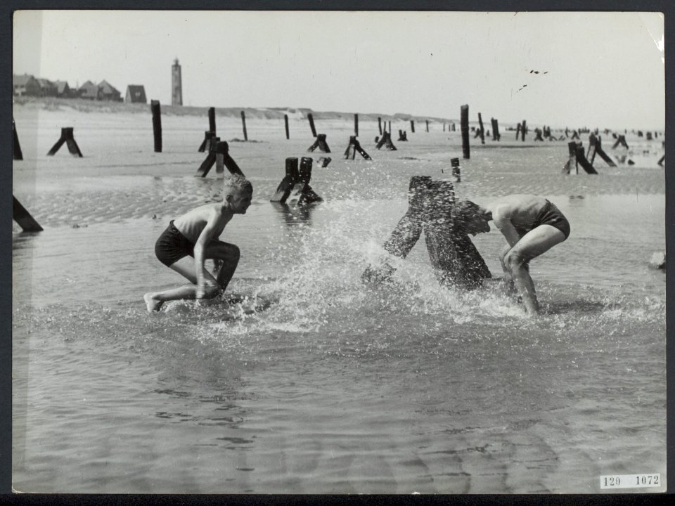 Jongens spelen op het strand van Noordwijk, tussen nog steeds aanwezige versperr, Bestanddeelnr 120-1072