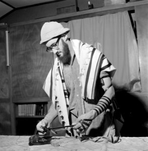 Joodse man met een hoedje op en een gebedsmantel om bezig met het aanleggen van , Bestanddeelnr 255-4704